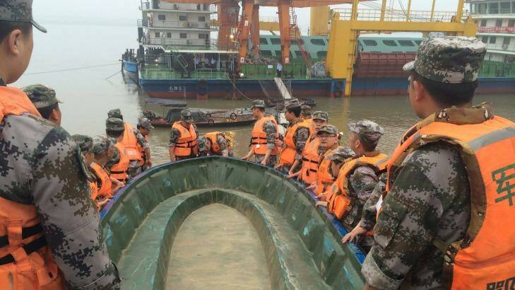 Rescue workers carry a boat as they conduct a search, after the ship sank in the Jianli section of the Yangtze River Photo: CSN