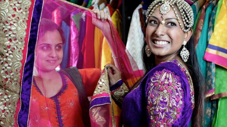 Shaleen Kumar assisted by Tamanna Bajaj tries on saris at Dulhan Exclusives in Liverpool, Sydney. Photo: Janie Barrett