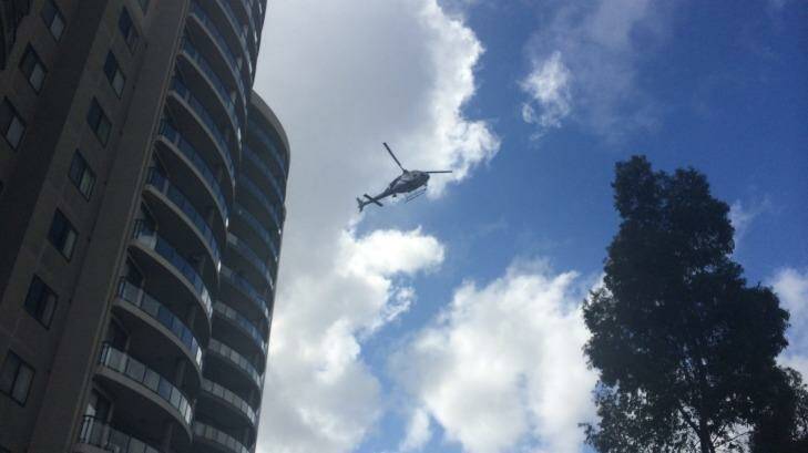 A police helicopter flies over a crime scene set up at the Monarco Estate complex in Westmead after a woman'??s body was found nearby. Photo: Emma Partridge