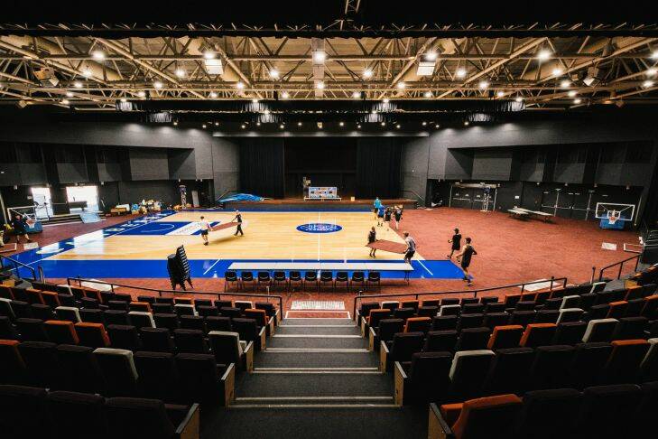 Workers removing panels to reveal the basketball court at the National Convention Centre ahead of the Canberra Capitals home game this weekend.