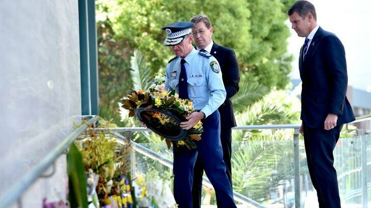 NSW Police Commissioner Andrew Scipione lays a wreath at a floral tribute for police accountant Curtis Cheng outside police headquarters in Parramatta on Tuesday, while Police Minister Troy Grant and Premier Mike Baird look on. Photo: Steven Siewert