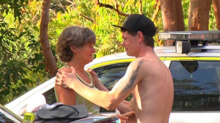 Nick Weston comforts the mother of a man who fell to his death at Somersby Falls. Photo: Top Notch Video