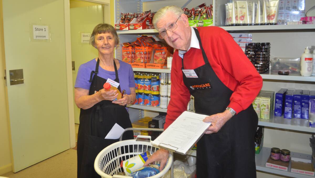 HELPING HAND: FoodCare committee member Anne Hopwood and volunteer Alan McAnulty.     0218tpfoodcare6