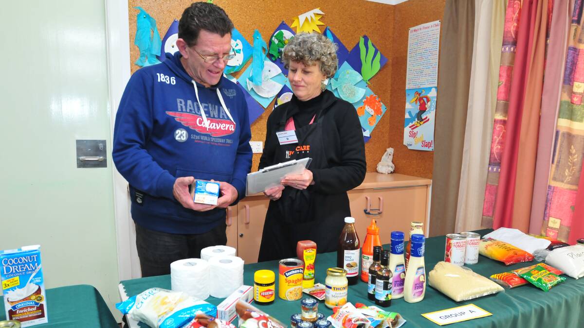 HELPING HAND: FoodCare food coordinator Di Aitken with customer Gary Johnstone yesterday. Photo: LUKE SCHUYLER 0505foodcare1
