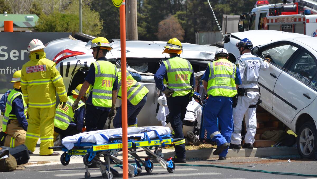 Emergency services personnel work to free a a woman trapped in her car after a two-vehicle accident on Monday at Orange hospital.