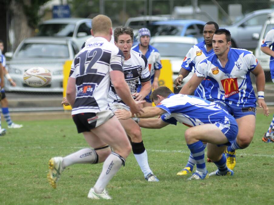 CHARGING: Cowra's Tim Holman (centre) gets the ball away in the Bathurst Panthers Rugby League Knockout final against Bathurst St Pat’s. Photo: CHRIS SEABROOK 031514cpats5