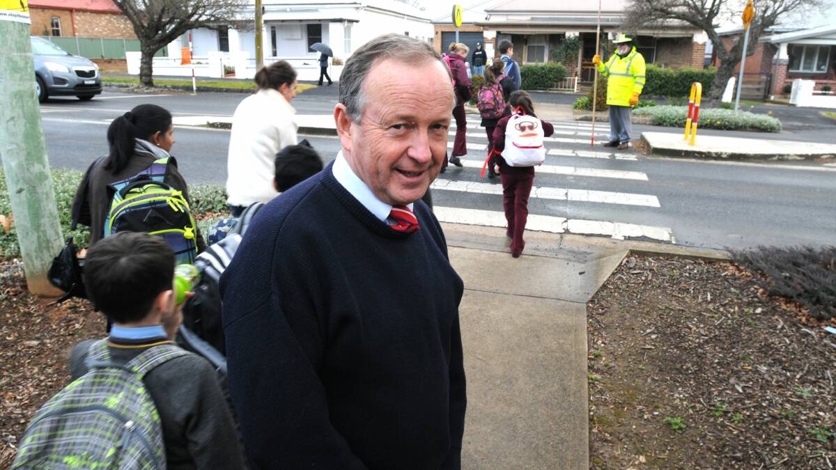 RUNNING THE GAUNTLET: Principal Michael Croke, pictured near one of his school’s busy crossings yesterday afternoon, believes flashing lights will help improve safety at Catherine McAuley Catholic Primary School. Photo: STEVE GOSCH 				               0717sgcrossing1

