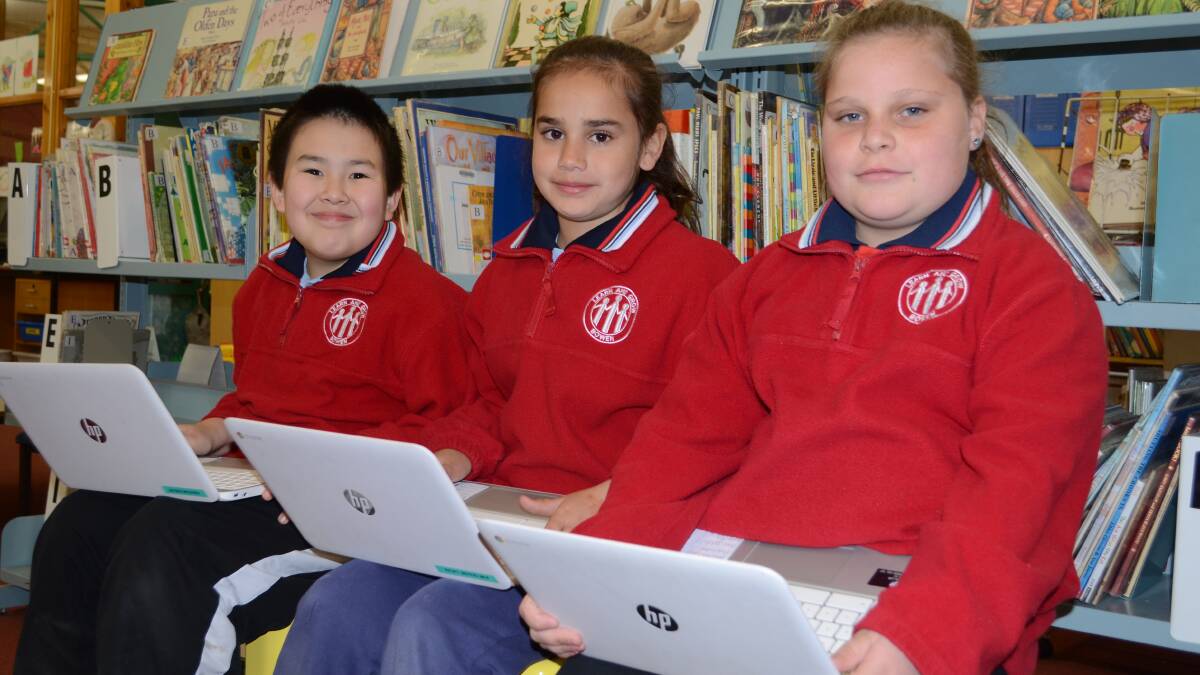 TECH SMART: Bowen Public School students Jayden Mussared, 10, Kimi Craigie-Lucas, 9, and Dakotah Caughlan, 10, have enjoyed using Chrome books in class since they were introduced earlier this year. Photo: TANYA MARSCKE	        0903tmbowen1

