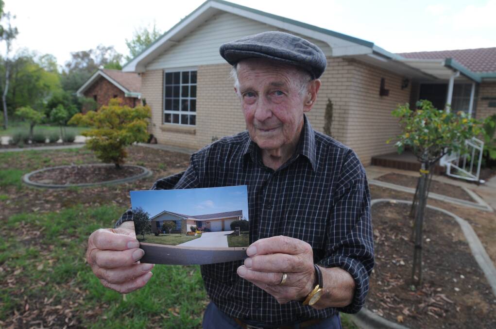TREE CHANGE: Kara Place resident Derek Parkes with a photo of his lawn before the eucalyptus tree was planted outside his home.  Photo: STEVE GOSCH