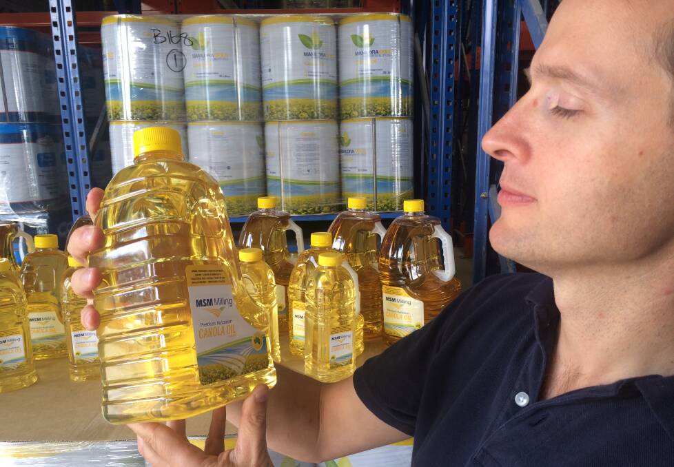 HUMBLE BEGINNINGS: Manildra Packing business manager Peter Jones with the first shipment of canola oil destined for the lucrative Chinese market.  Photo: GENYA MILLER
