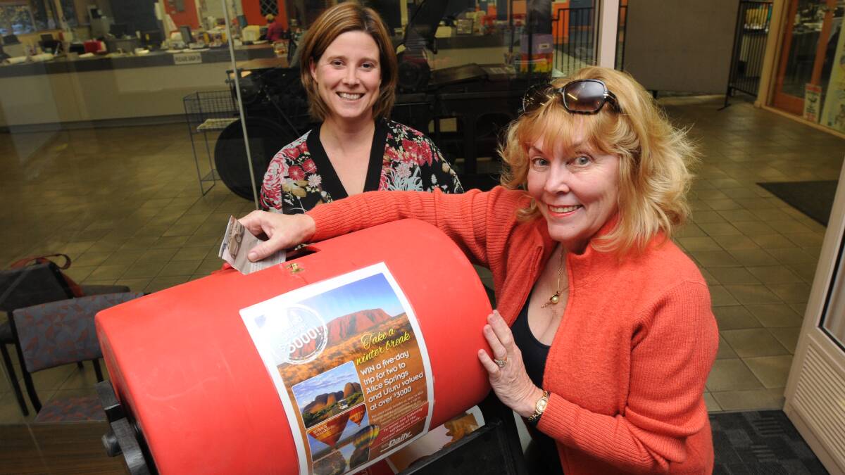 AND THE WINNER IS: Travel World consultant Gai Fardell and Central Western Daily advertising manager Rochelle Monaghan draw the winning entry in the trip to Alice Springs and Uluru. Photo: STEVE GOSCH 0501sgdraw1
