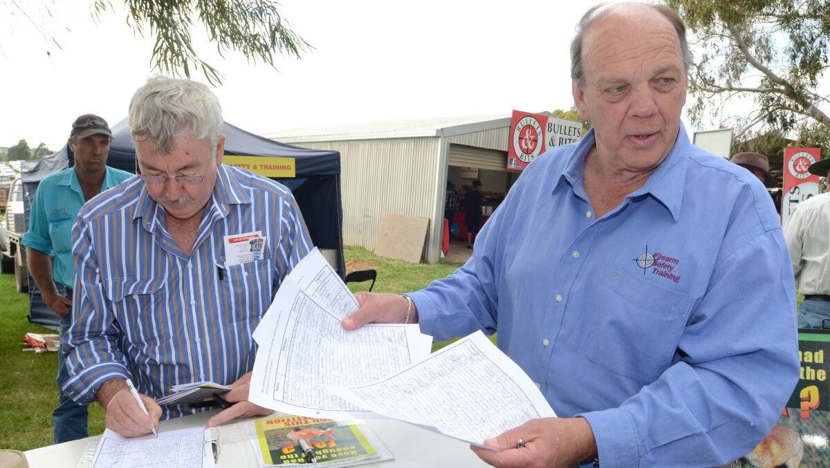 BOUNTY HUNTER: Australian National Field Days exhibitor Gary Bryant (right) is calling for the reintroduction for a bounty on foxes. Geurie’s Martin Whiteley put his signature to the petition. Photo: JUDE KEOGH 1024fielddays7