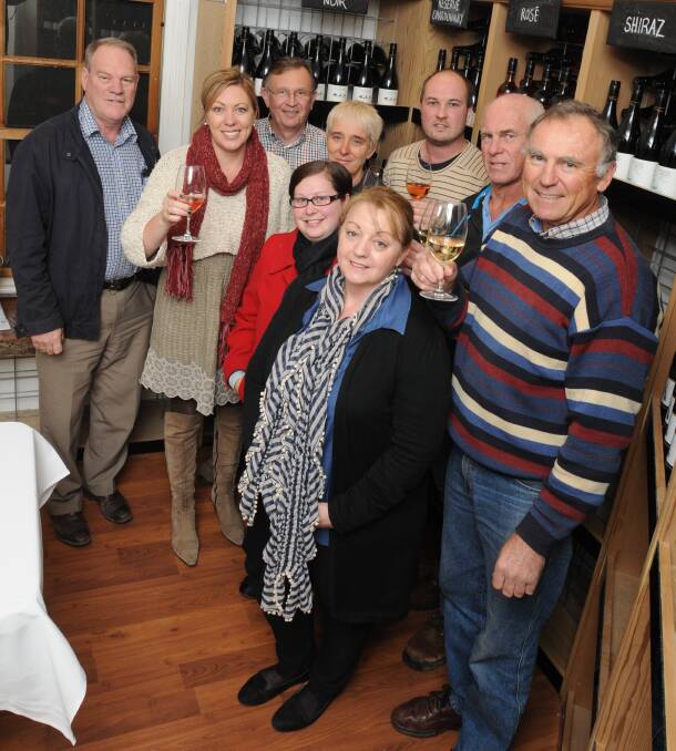 ROLL OUT THE BARREL: (Back) Dave Zinga, Michelle Stivens, David Crawley, Michelle Davies, Nick Garton, Peter Mortimer, Peter Hedberg, (front) Karina Gowan and Sandra Kelly celebrate the extension of Wine Week. Photo: STEVE GOSCH 0619sgwine