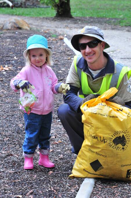TEAM WORK: Millie and Mark Gliddon help pick up some of the two-and-a-half tonnes of rubbish collected during yesterday’s Clean Up Australia Day activities in Orange. Photo: JUDE KEOGH  0302cleanup2