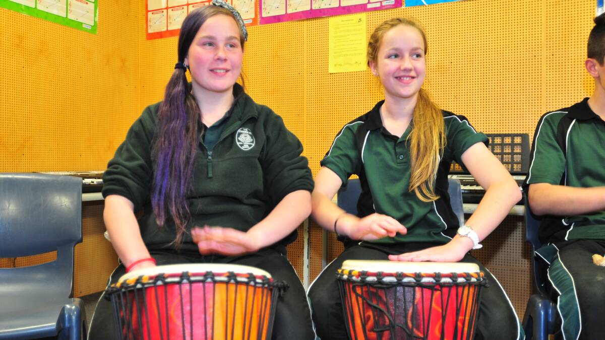 FUN WITH DRUMS: Canobolas Rural Technology High School students Amelia Koller and Sidney Ewins learn to play drums at a workshop on Tuesday. Photo: LUKE SCHUYLER 0826lsdrums1
