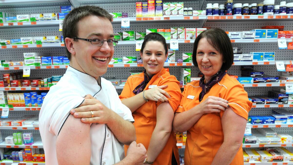 GIVE IT A SHOT: Pharmacist Tim Denham, Kayli Kells and Lindy Wigmore prepare for their flu shot. Photo: Steve Gosch 0321sgflu2 