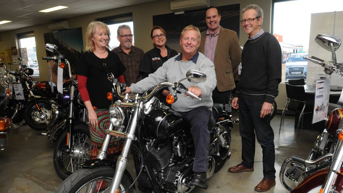 KING OF THE ROAD: John Godwin tries out his Harley-Davidson after being congratulated by Robyn Brice, Les Borgstahl, Louise Bradstreet, Will Armstrong and Stuart Smith. Photo: STEVE GOSCH             0606sgharley1