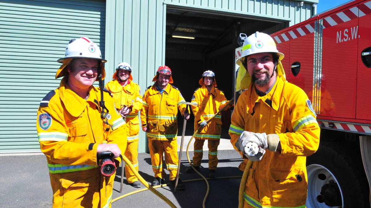 FIRING UP: Rural Fire Service volunteers (front) Phil Pedley and Simon Smith with (back) Craig Wright, Troy Kelly and Mark Gray will show off their fire trucks at the open day on Saturday. Photo: JUDE KEOGH 0911fireopenday1