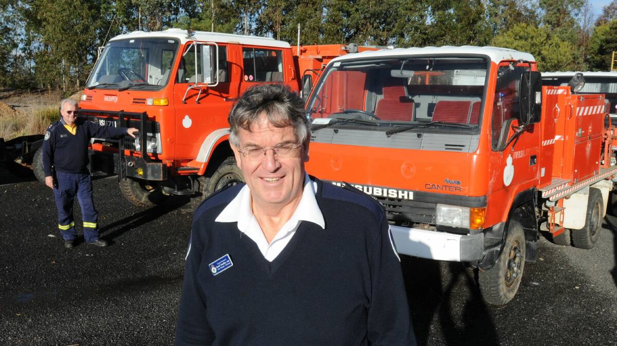 PUT TO PASTURE: Seven RFS vehicles, pictured with Canobolas Zone manager David Hoadley and infrastructure and assets co-ordinator Arthur Sharp (back) have been retired, to be auctioned to the highest bidder next month. Photo: STEVE GOSCH 0728sgrfs3
