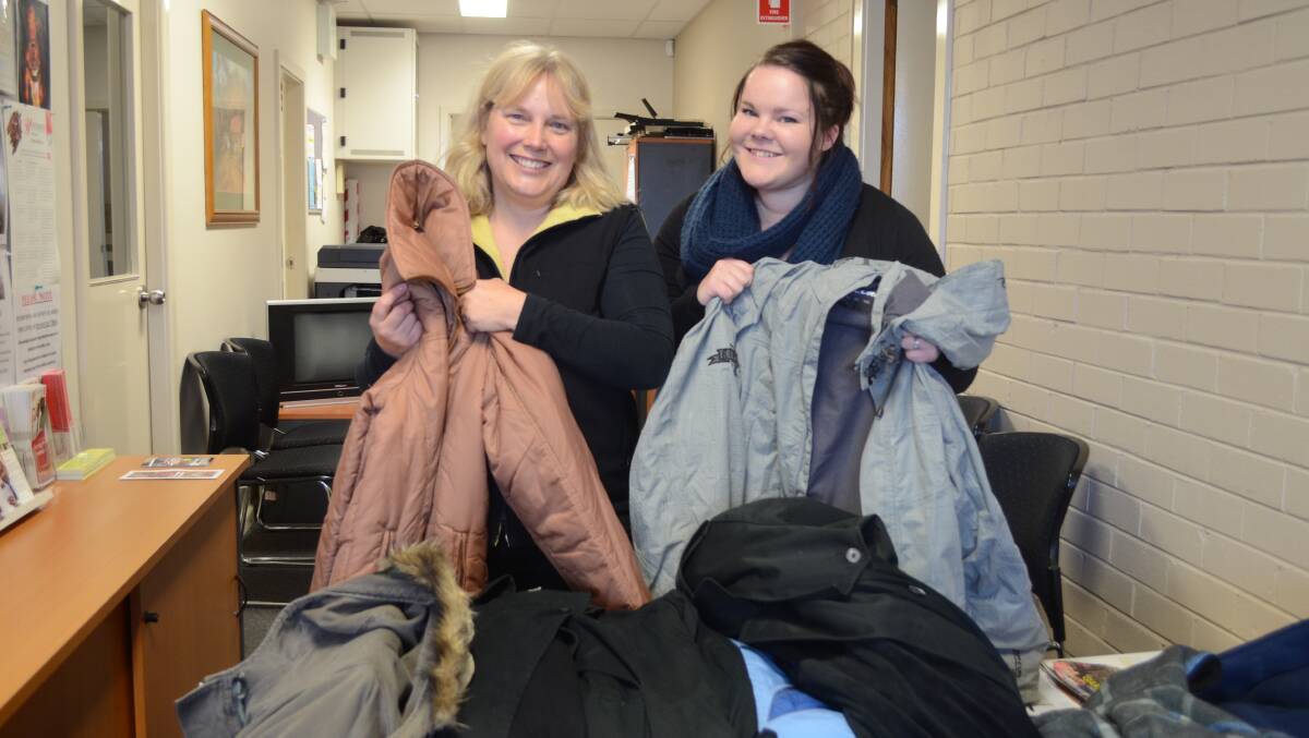 COATS GALORE: Salvation Army’s Karen Saunders and Tabitha Johnstone sort through the 100 coats that have been donated to the store as part of the Coats for Everyone campaign. Photo: LUKE SCHUYLER 0718lscoats1