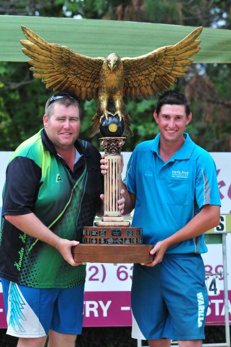 EAGLE EYE: Warilla pair Jeremy Henry and Jared Hamilton, pictured with the Golden Eagle trophy, proved too strong in yesterday’s final, claiming the 2014 crown with a 25-15 victory. Photo: JUDE KEOGH 0313eaglefinal2