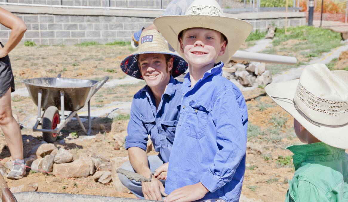 BANDING TOGETHER: Dave Jeffress and his son Will help build the Orange Anglican Grammar School kitchen garden after the community raised thousands of dollars to support Will after an accident landed him in intensive care for three weeks. Photo: LEN ELLIOTT