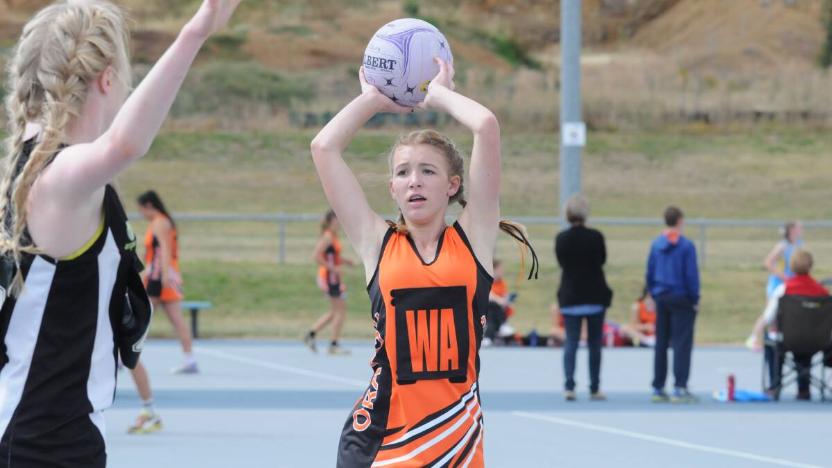 WE ARE THE CHAMPIONS: Under 15s gun Mariah Robinson teammates took out the State League division three title on Sunday. Photo: JUDE KEOGH        0322netball9