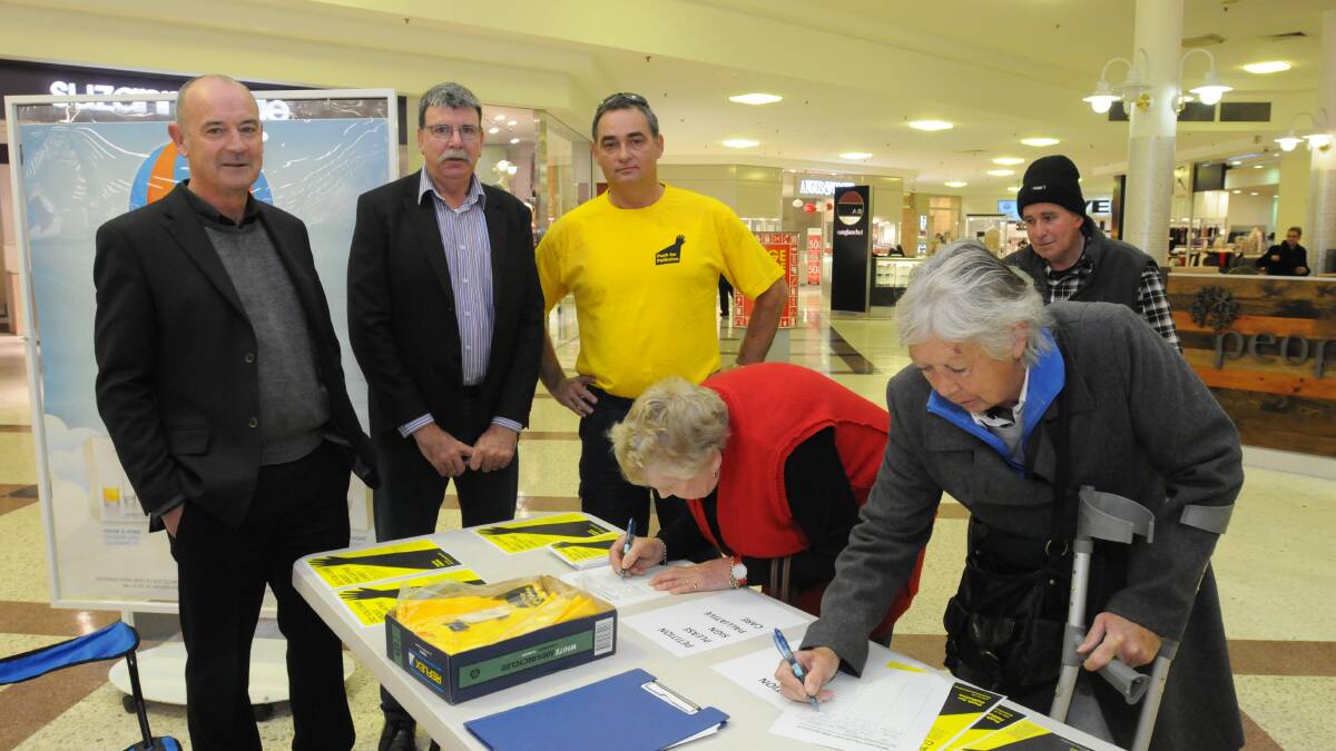 SIGNING FOR PALLIATIVE CARE: Orange councillor Glenn Taylor and Push for Palliative members Bernard Fitzsimon (left) and Joe Maric watch as Helen Redgrave and Loraine Lane sign the petition calling for better palliative care services in Orange. Photo: JUDE KEOGH 0529palliative1