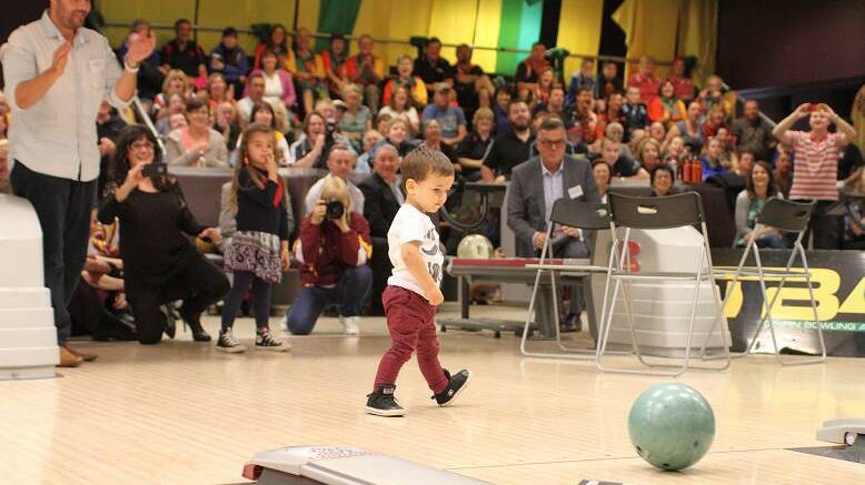 HAPPY WITH THAT: Hugo Belmonte shows his dad Jason how it's done at Sydney's Tenpin City this week.