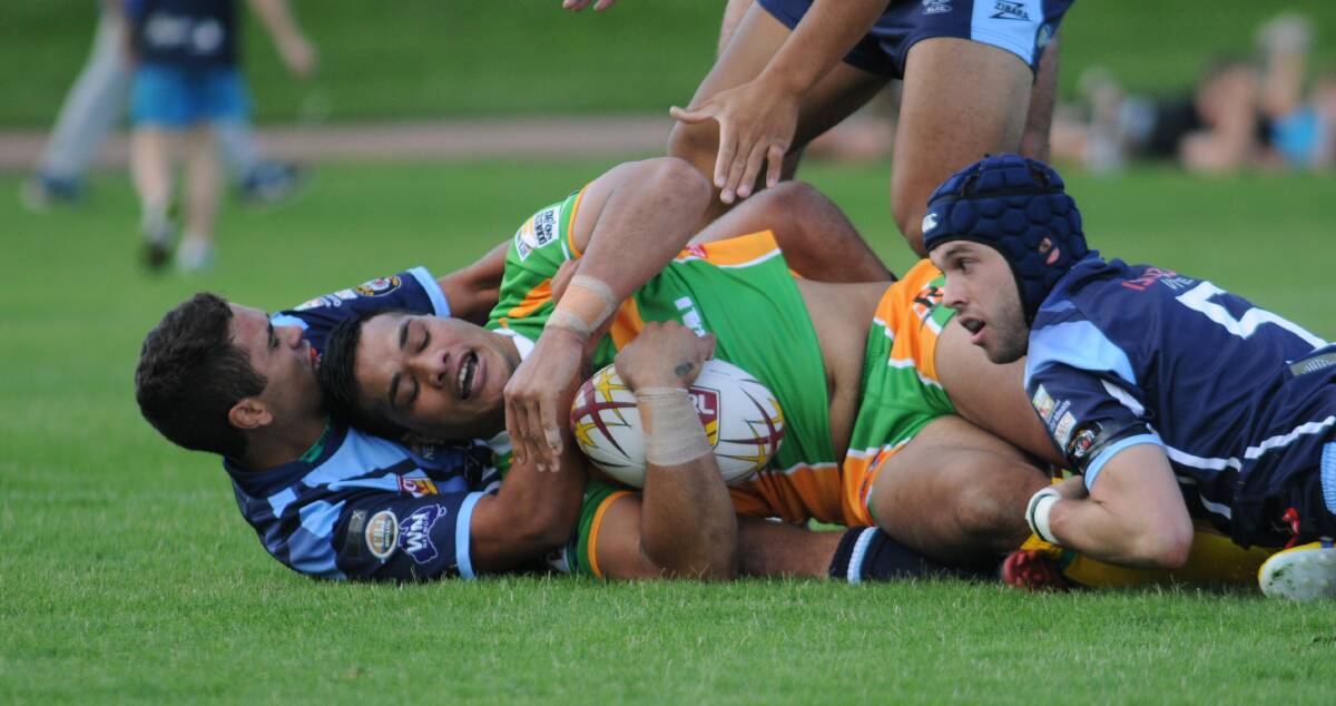 ORANGE CYMS: Semisi Katao is wrapped up by the Hawks defence. Photo: STEVE GOSCH