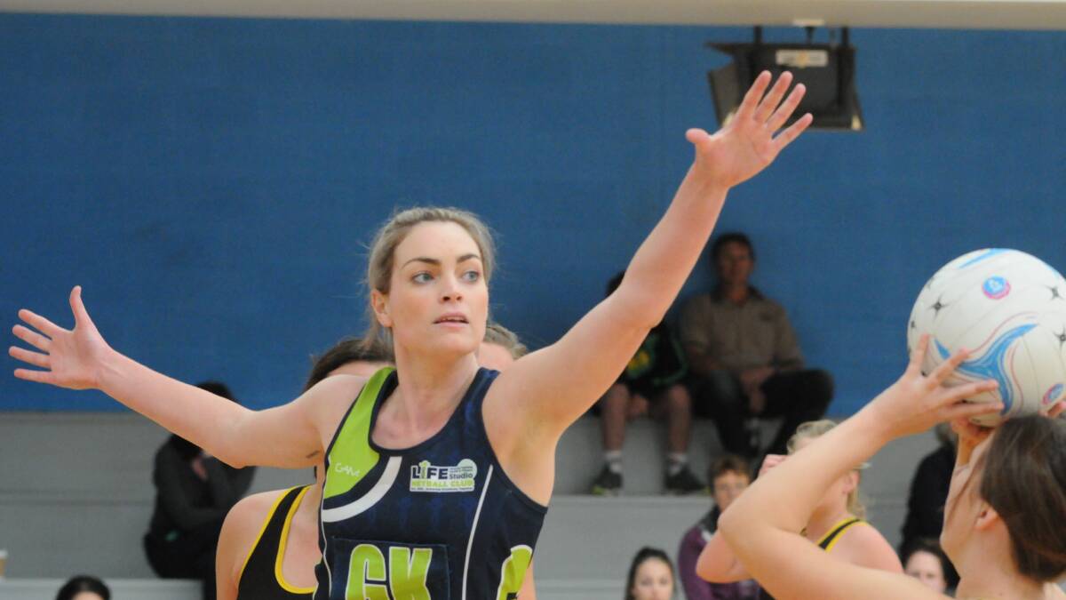 BIG REACH: Life Studio's Em Brotherton does her best to crowd the High A attack on Saturday. Photo: JUDE KEOGH