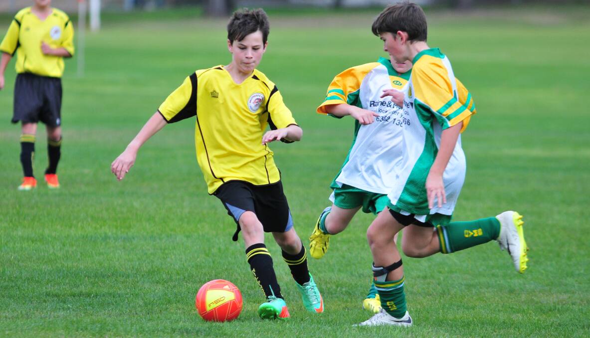 ATTACK THE BALL: Millthorpe's Ethan Jones tries to get the better of tow CYMS' opponents. Photo: JUDE KEOGH