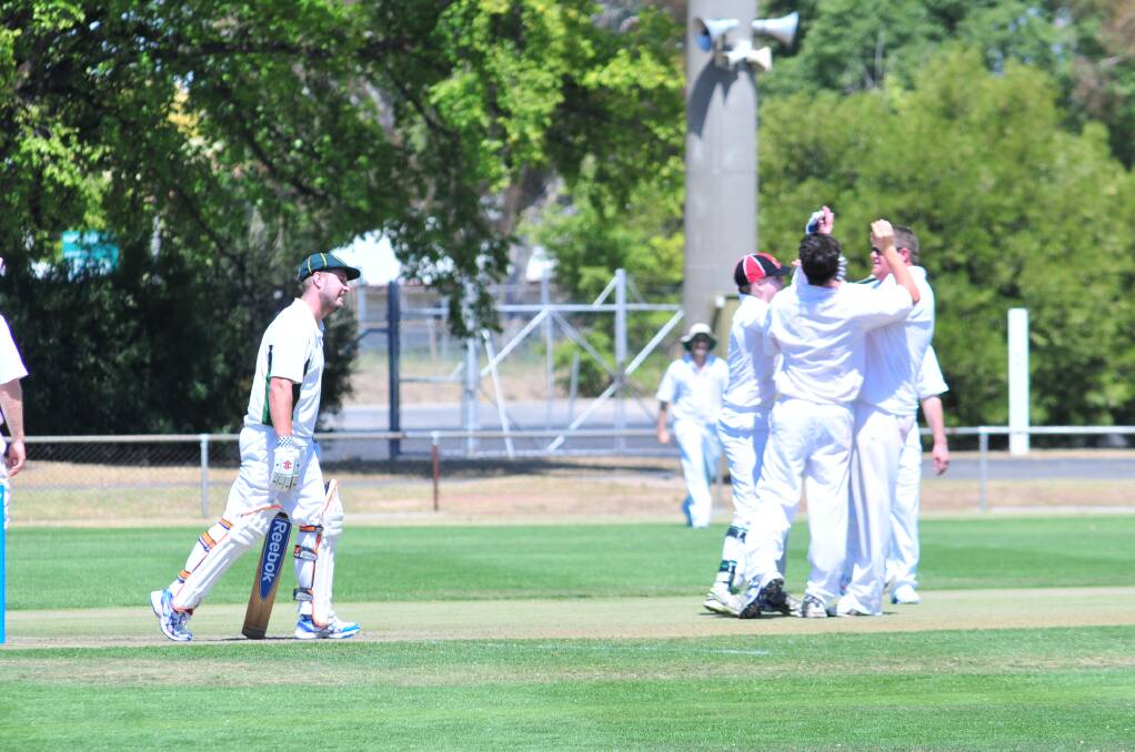 Centrals players gather around Dean Turner to celebrate the wicket of Nick Garton in Saturday's ODCA first grade game at Wade Park. Photo: JUDE KEOGH