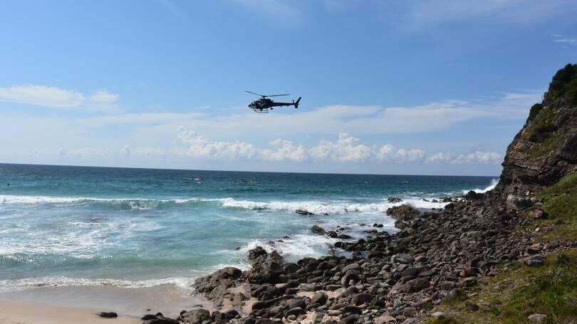SEARCHING: A helicopter's pilot and passengers scan the waters off Boomerang Beach on Monday. Photo: GREAT LAKES ADVOCATE