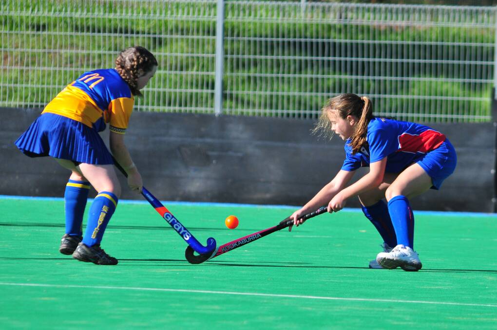 HOCKEY: Charlie Wentworth and Sarah Kirkness battle for possession of the ball on Saturday morning. Photo: JUDE KEOGH