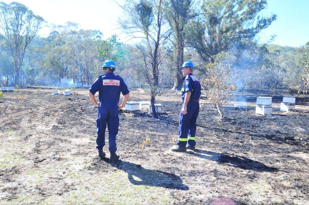 ORANGE: INVESTIGATION: The Rural Fire Service’s Mike Spira and Steve Smith at the site of the Lower Lewis Ponds Road fire yesterday. Photo: JUDE KEOGH