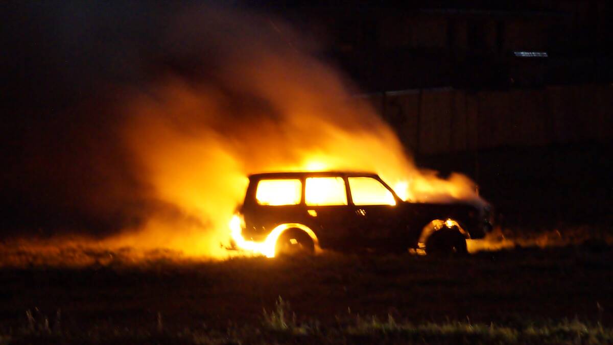 LIGHTING UP THE NIGHT SKY: Orange resident Shane Lear took this photo of the car alight in a Spring Street park on Saturday night.