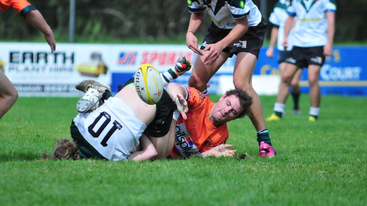 RUGBY UNION: Orange City Lions' Jake Davis is handled by the Orange Emus' defence at Endeavour Oval on Saturday. Photo: JUDE KEOGH