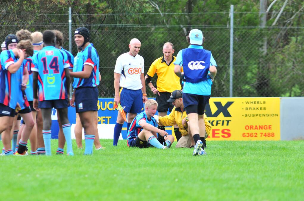 DOWN, BUT NOT OUT: One of the Western NSW players receiving treatment. Photo: JUDE KEOGH