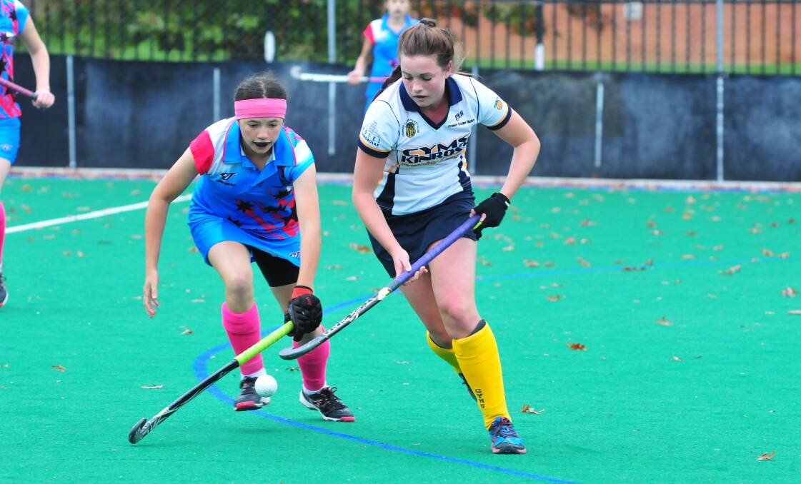 WATCH ME GO: Kinross-CYMS' Maddie Smith tries to run away from Dubbo Blue Jays' Gemma Mitchell at the Orange Hockey Centre. Photo: JUDE KEOGH