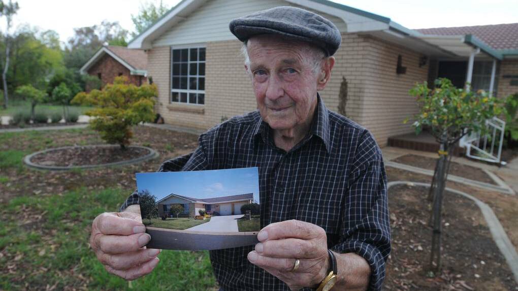 ORANGE: Kara Place resident Derek Parkes with a photo of his lawn before the eucalyptus tree was planted outside his home. Photo: STEVE GOSCH