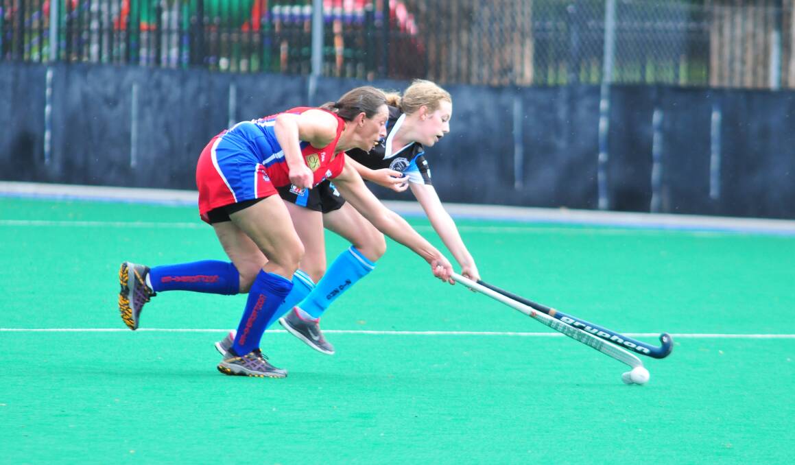HOCKEY: Renee Burrell fights for possession in Premier League Hockey on Saturday. Photo: JUDE KEOGH