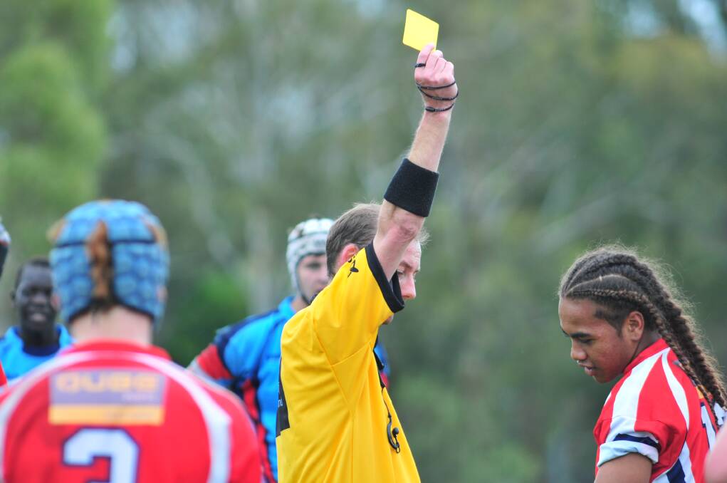ENOUGH OF THAT: Referee Jarrod Simpson shows the yellow card. Photo: JUDE KEOGH