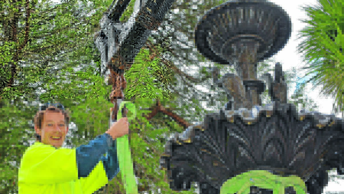 BIG JOB: With the assistance of a crane, Bondi Stone’s Conor Cullinan helps lift the historic James Dalton Fountain from its Cook Park home onto a truck. Photo: SUPPLIED