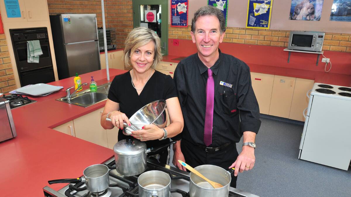 COOKING WITH GAS: Orange Christian School principal Melissa Brown and community relations coordinator Peter Cooper gear up for the school’s fundraising dinner on Friday night. Photo: JUDE KEOGH. 0218christian2