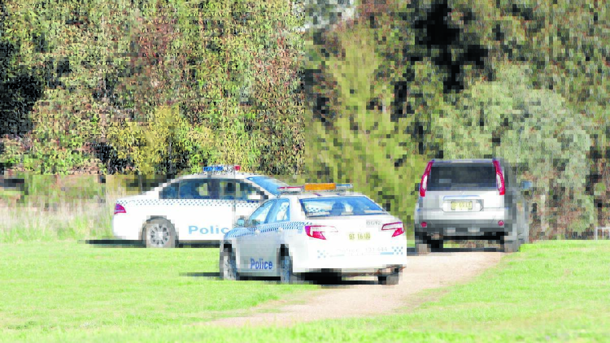 CRIME SCENE: Police cars surround the area where the body was discovered yesterday afternoon. Photo: MEGAN FOSTER