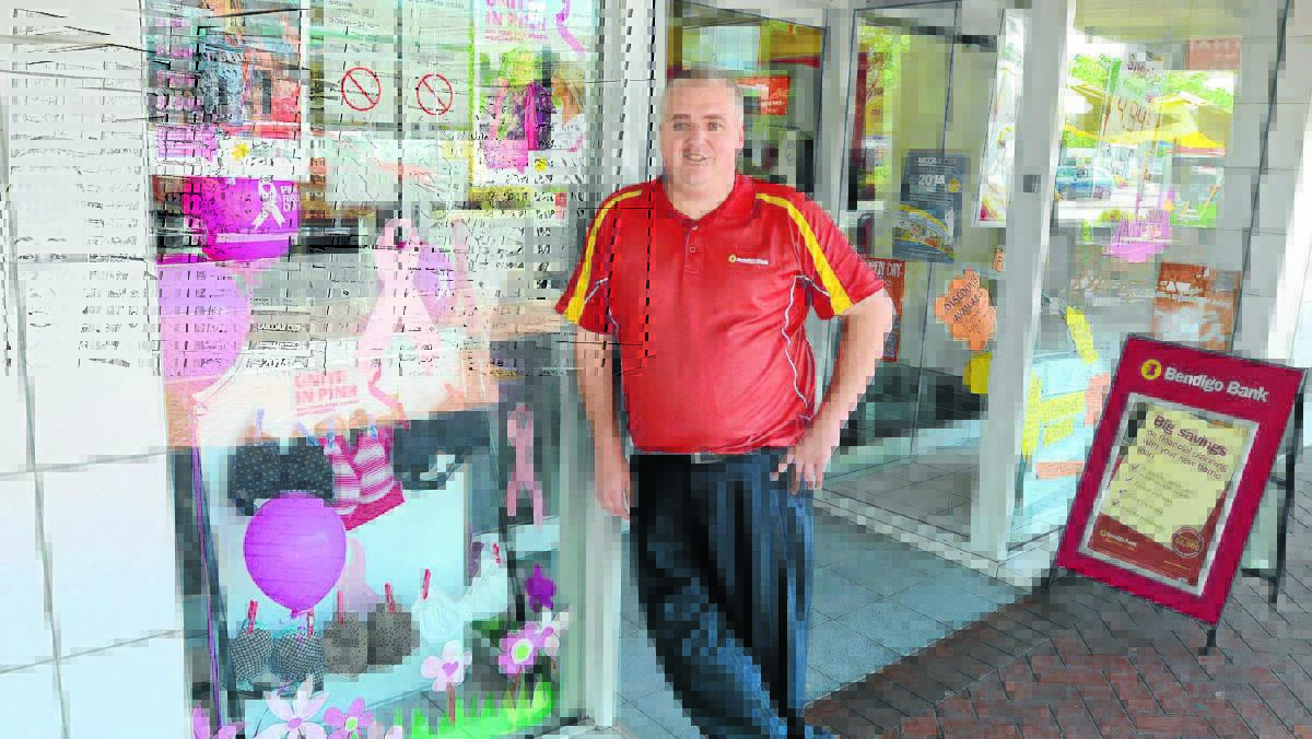 PINK PARADISE: Bendigo Bank business banking officer Ian Kenney with the bank’s window, decked out for Pink Ribbon Day.
Photo: JUDE KEOGH 1023bendigo1
