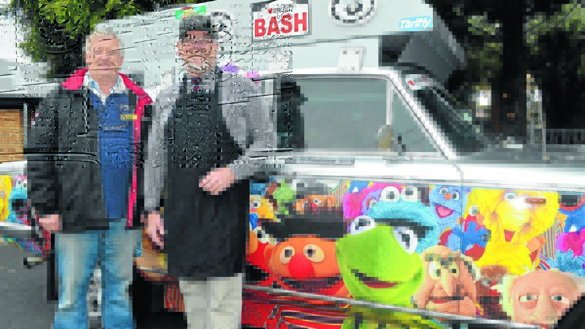 FOR THE KIDS: WA Variety Bash co-ordinator Geoff Kemp and Anson Street School principal Gary Brotherton in front of the bash’s most popular and successful fundraising vehicle starring members of Sesame Street and The Muppets. 
Photo: LUKE SCHUYLER 0819lsbash1
