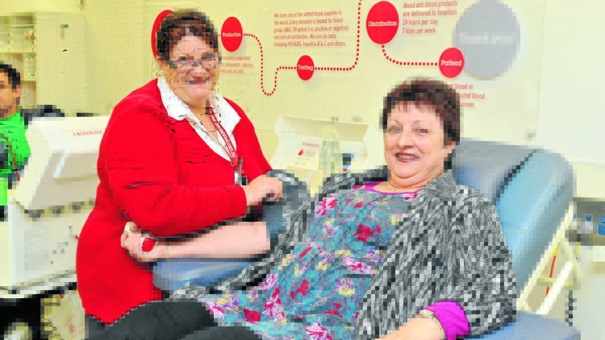 WILLING DONOR: Blood Donor Centre nurse Deborah Housler prepares Janelle Beath for a blood donation yesterday.
Photo: JUDE KEOGH 0728bloodbank1
