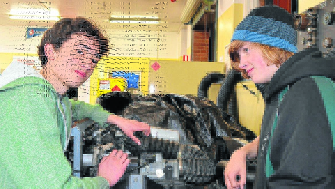 VOCATIONAL OPPORTUNITY: Year 10 students Paul Cozens and Daniel Maxwell examine an engine in the automotive workshop during the TAFE open day in Orange on Wednesday. Photo: TANYA MARSCHKE               0729tmtafe1
